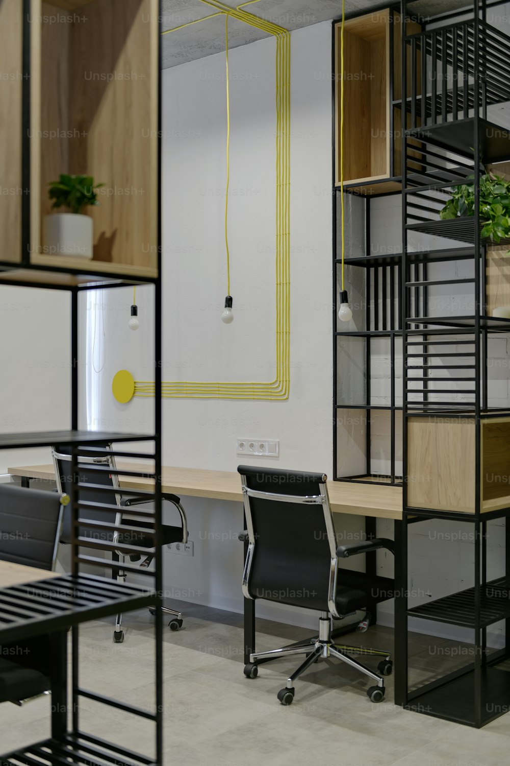 a room with a desk, chair, shelves and a plant