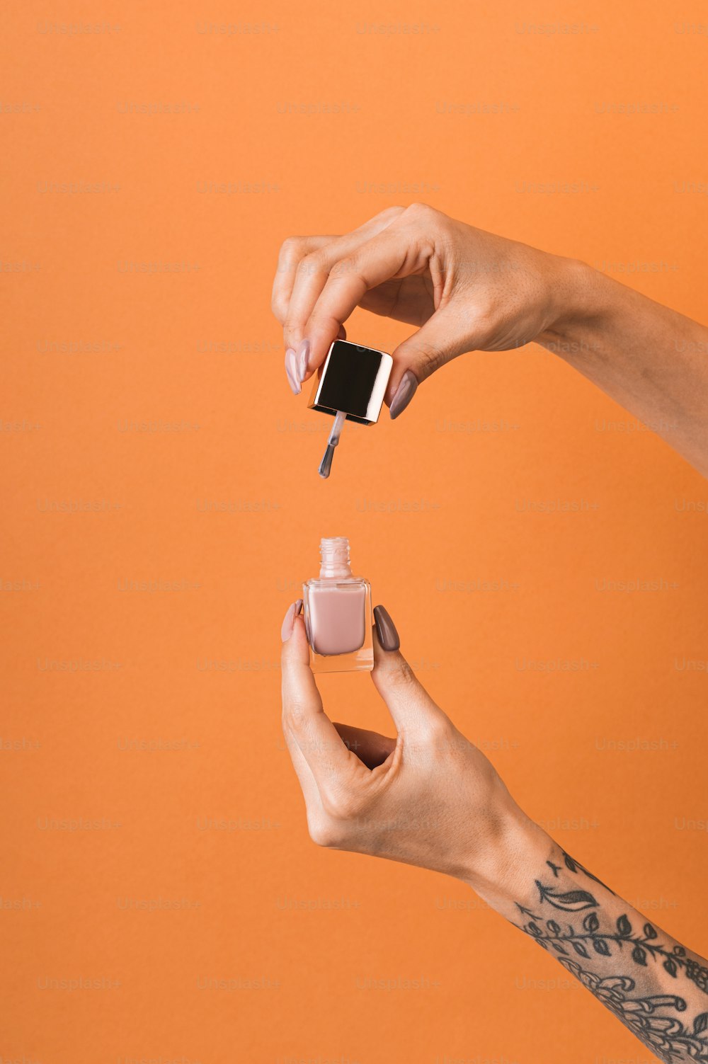 a woman holding a bottle of nail polish in her hand