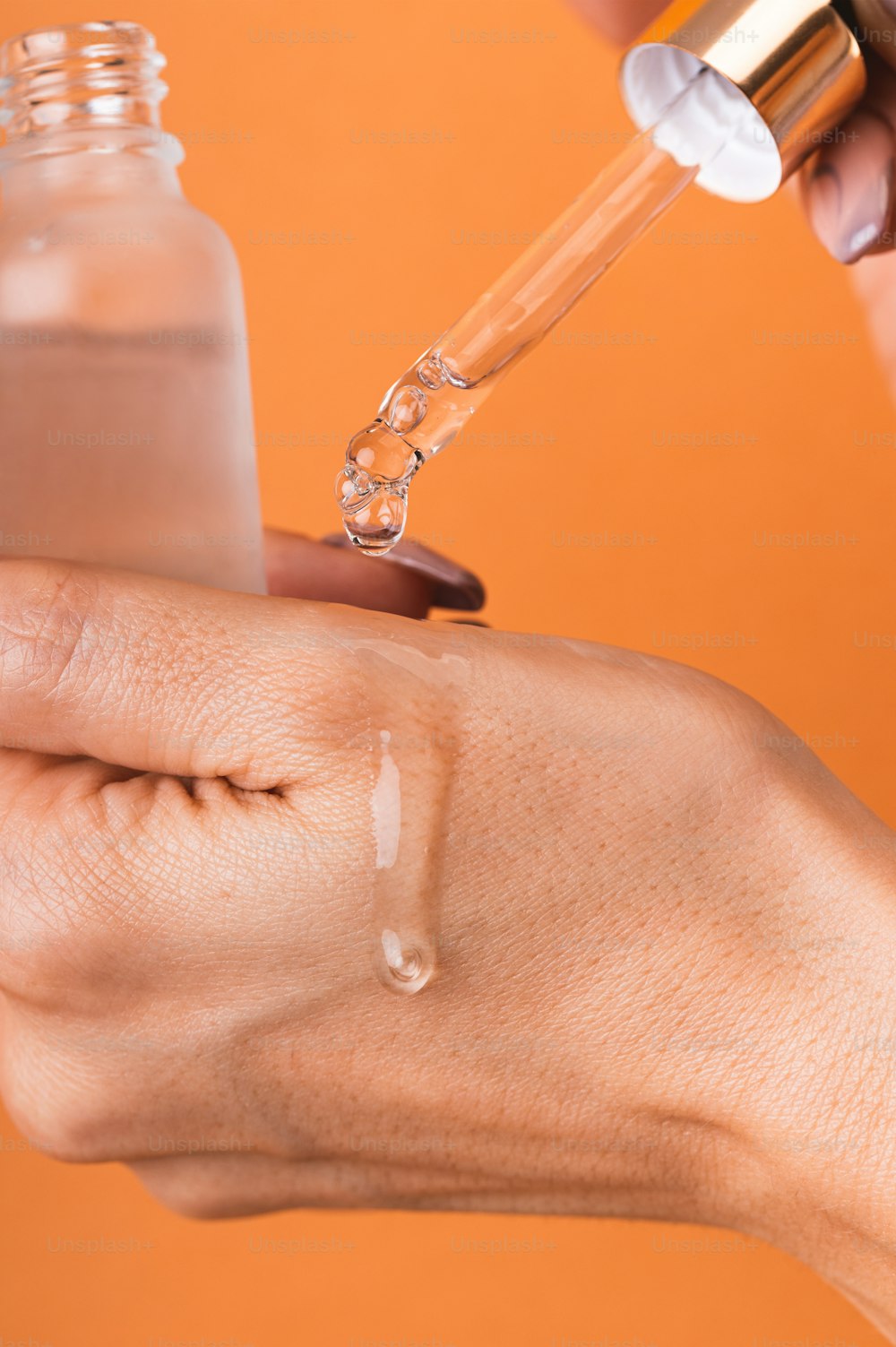 a hand holding a small bottle of liquid