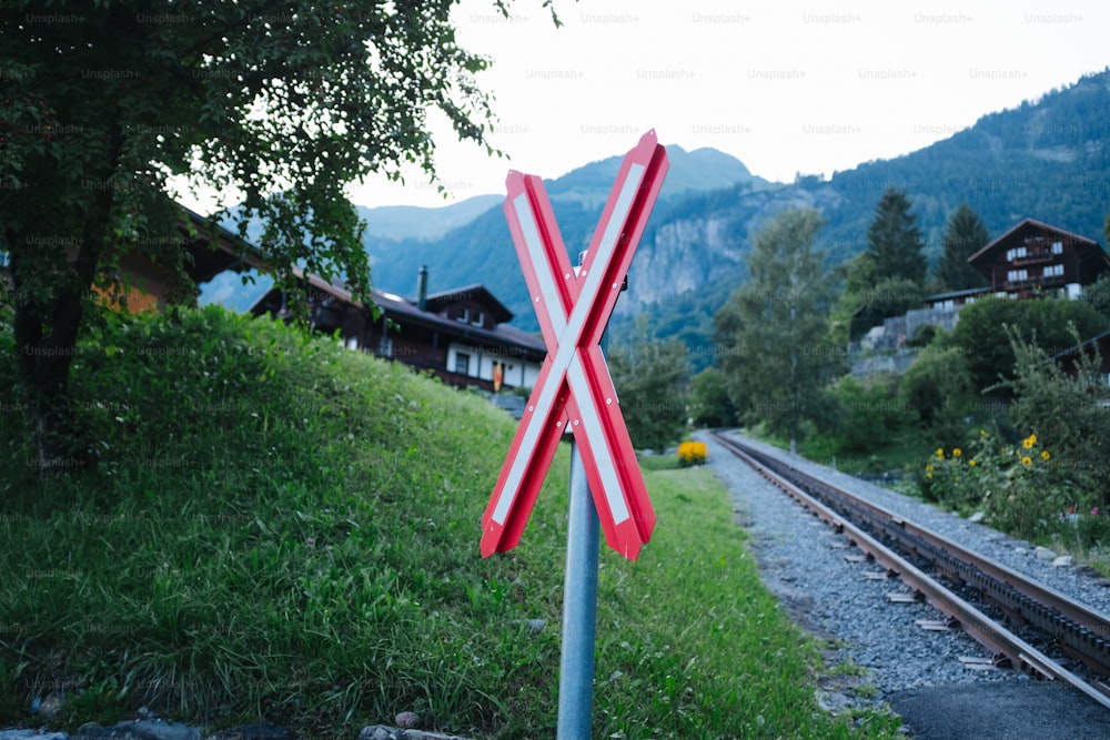 a railroad crossing sign sitting on the side of a train track