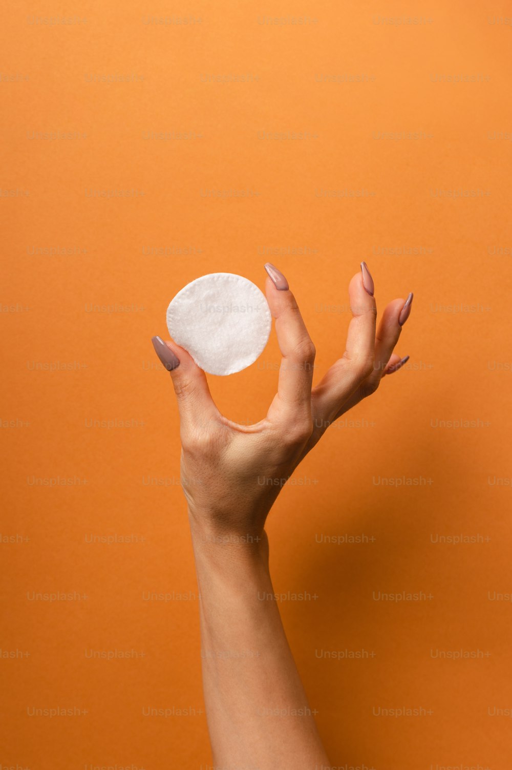 La mano de una mujer sosteniendo un pedazo redondo de papel