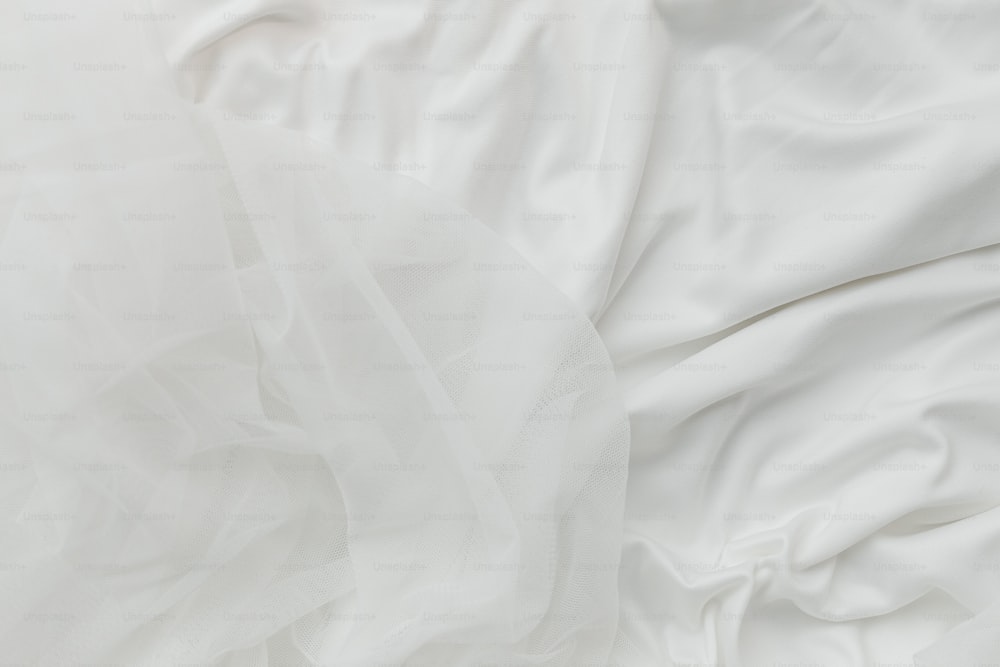 a close up of a bed with white sheets