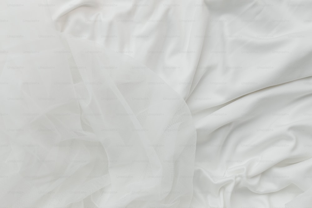 eine Nahaufnahme eines Bettes mit weißen Laken