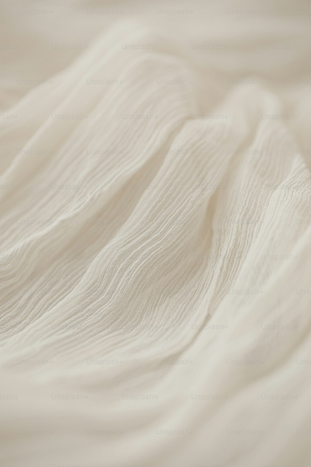 um close up de uma cama com lençóis brancos