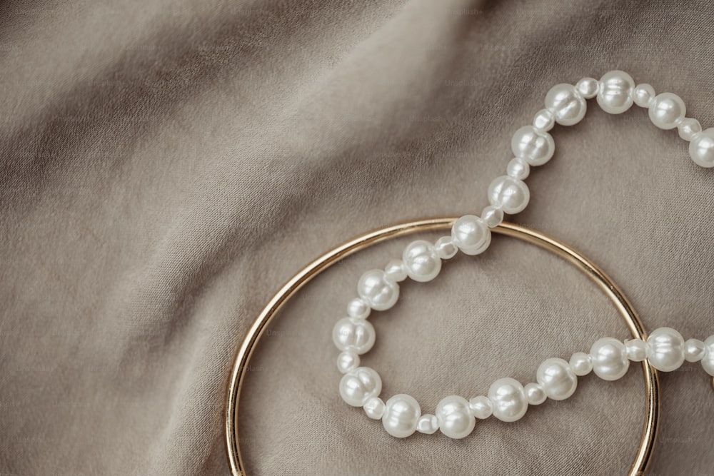 a close up of a pair of pearls on a gold hoop