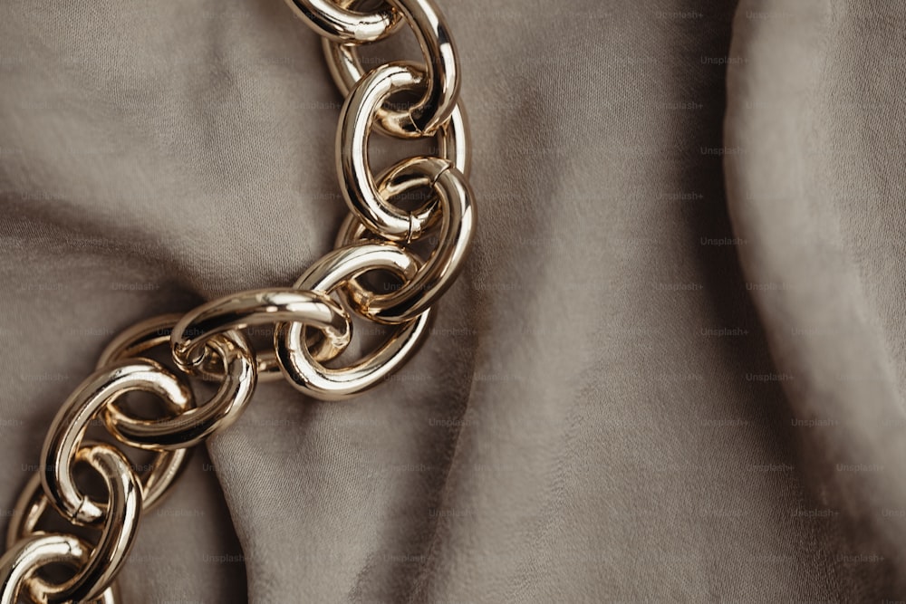 a close up of a gold chain on a fabric