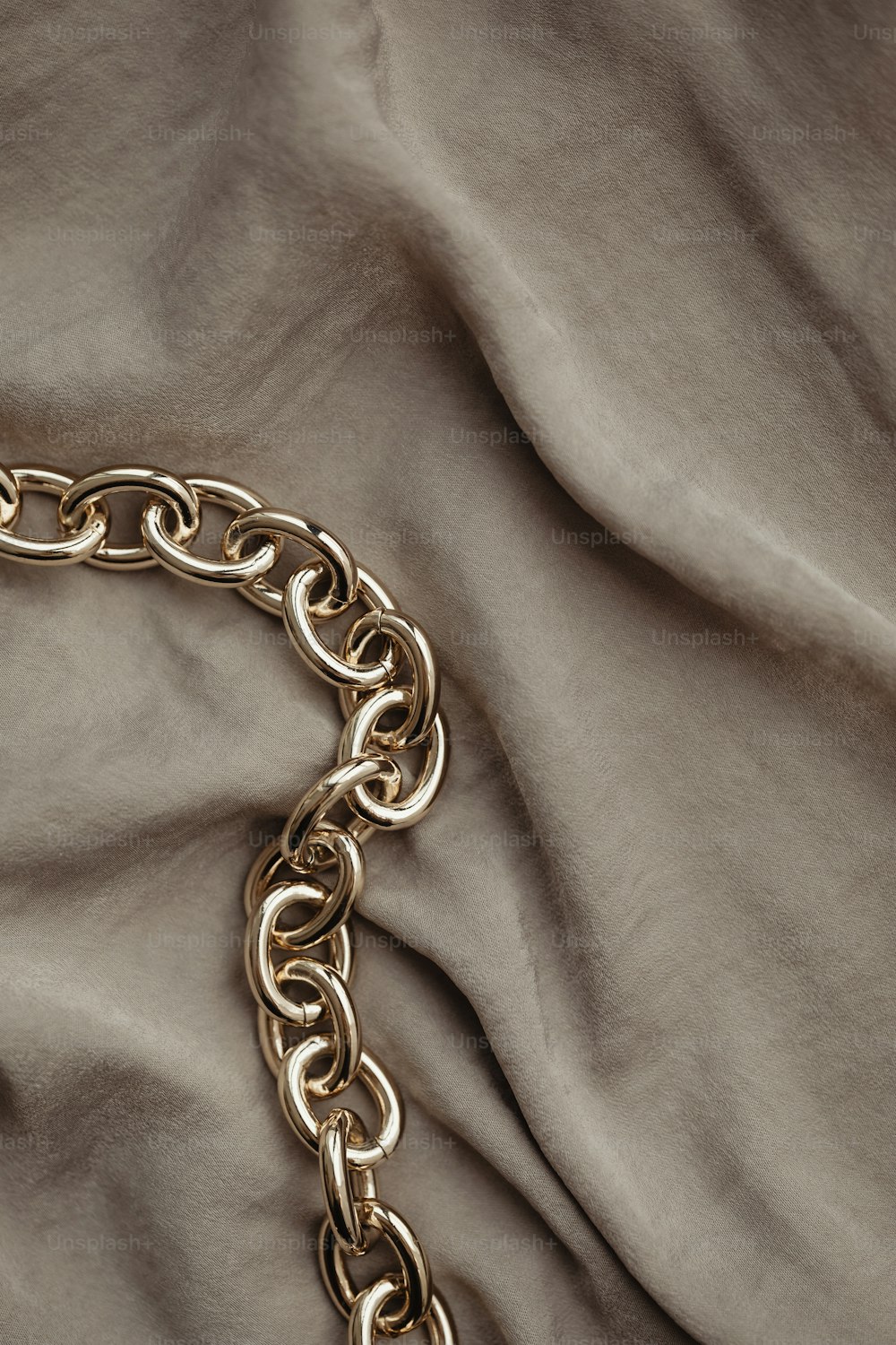 a close up of a gold chain on a bed