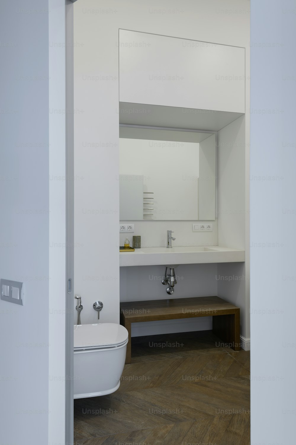 un cuarto de baño con inodoro, lavabo y espejo