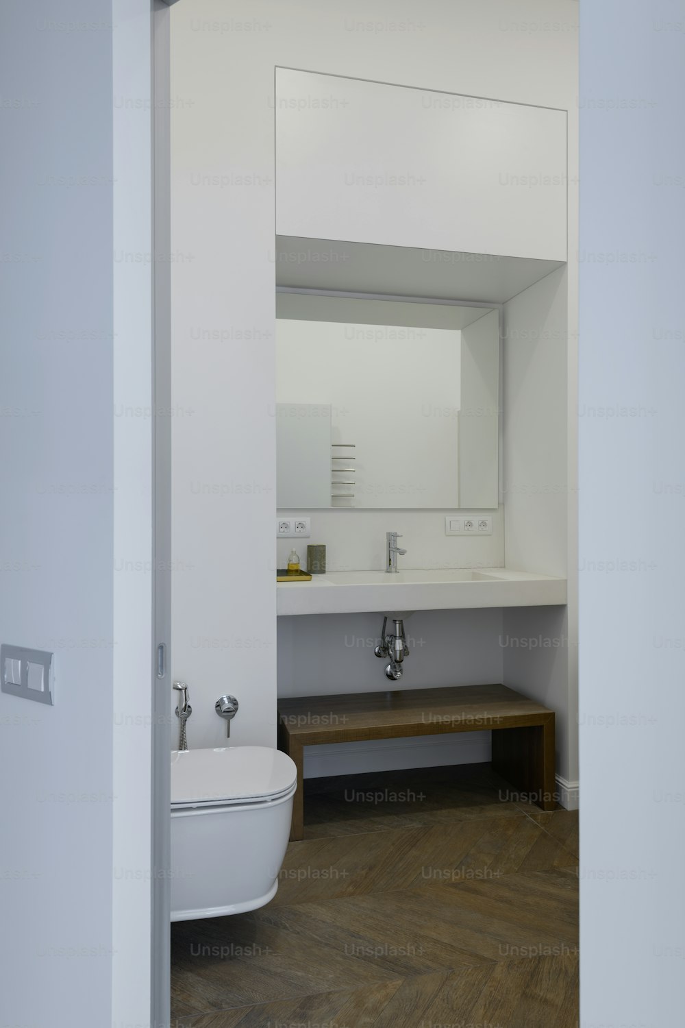 a bathroom with a toilet, sink and mirror