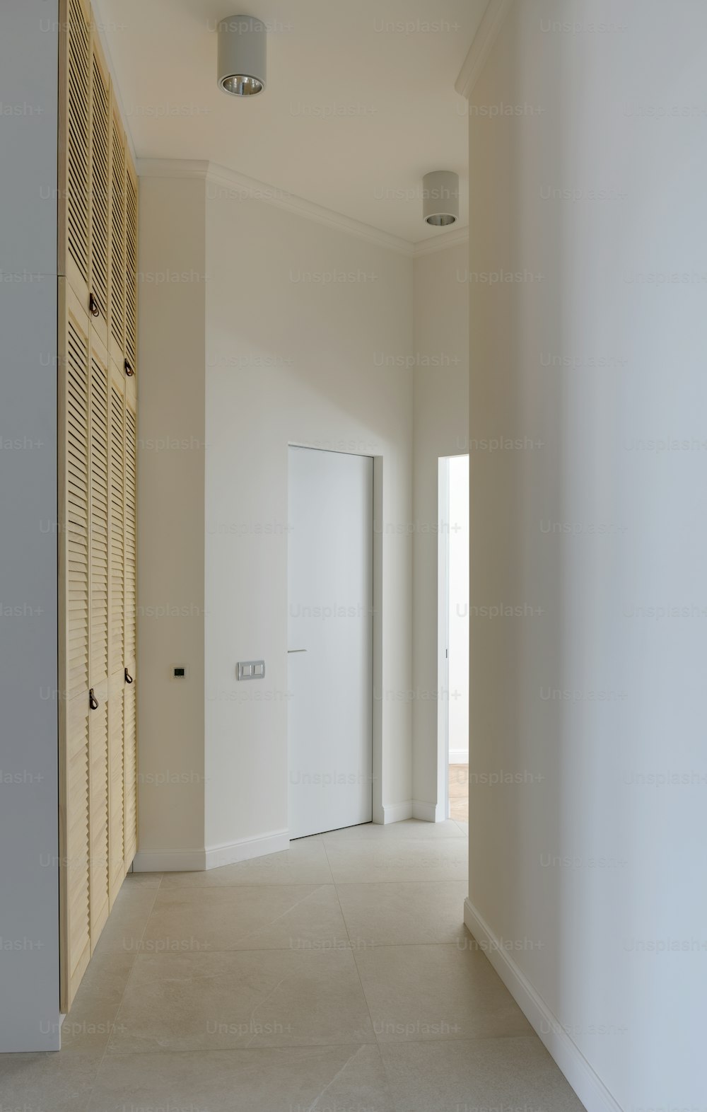 an empty room with a white door and a white wall