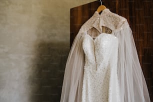 a wedding dress hanging on a hanger