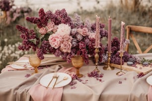 Una mesa cubierta con flores rosadas y velas