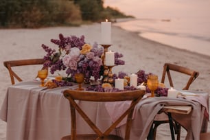 Una mesa instalada en la playa con flores y velas