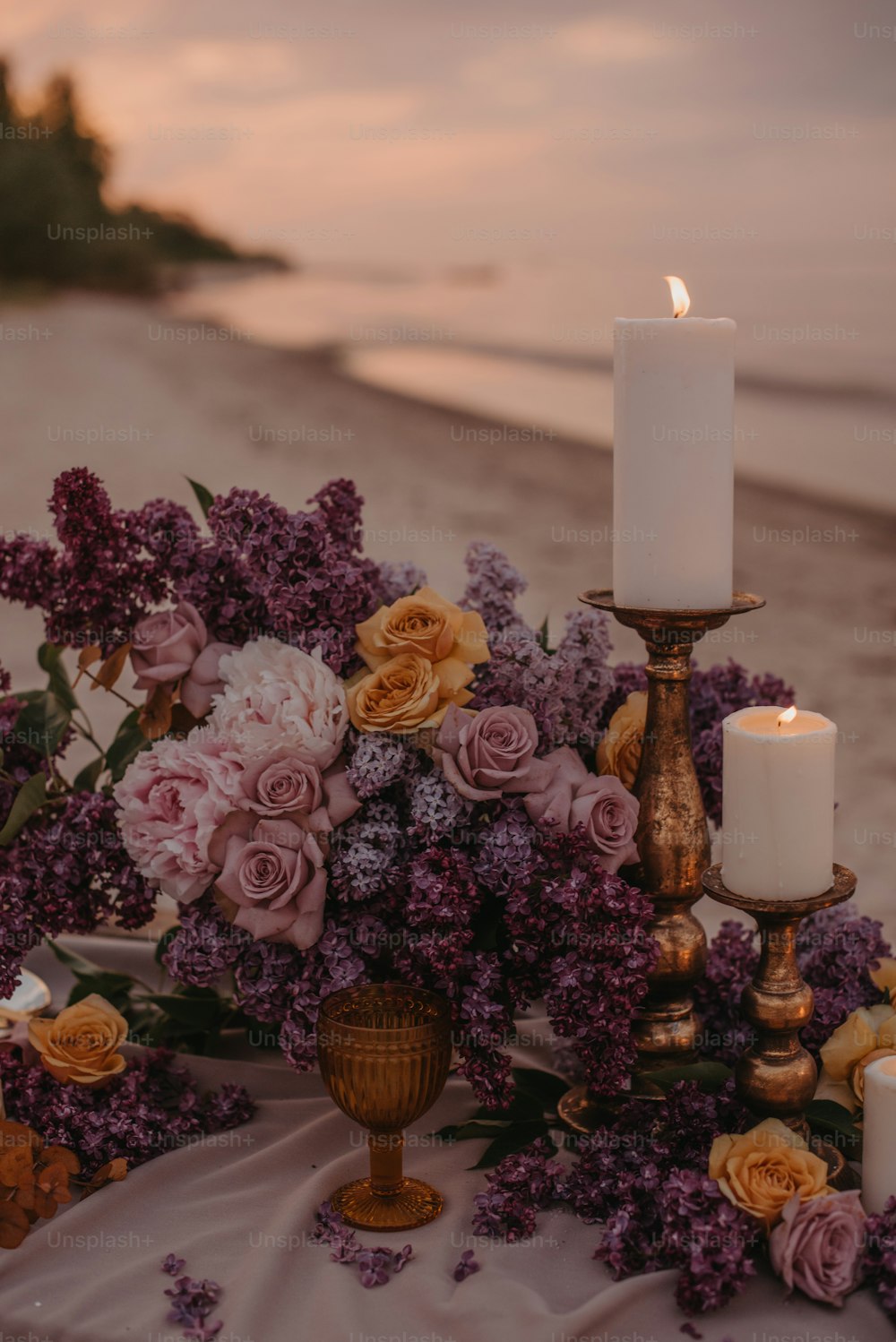a table topped with a vase filled with flowers and a candle