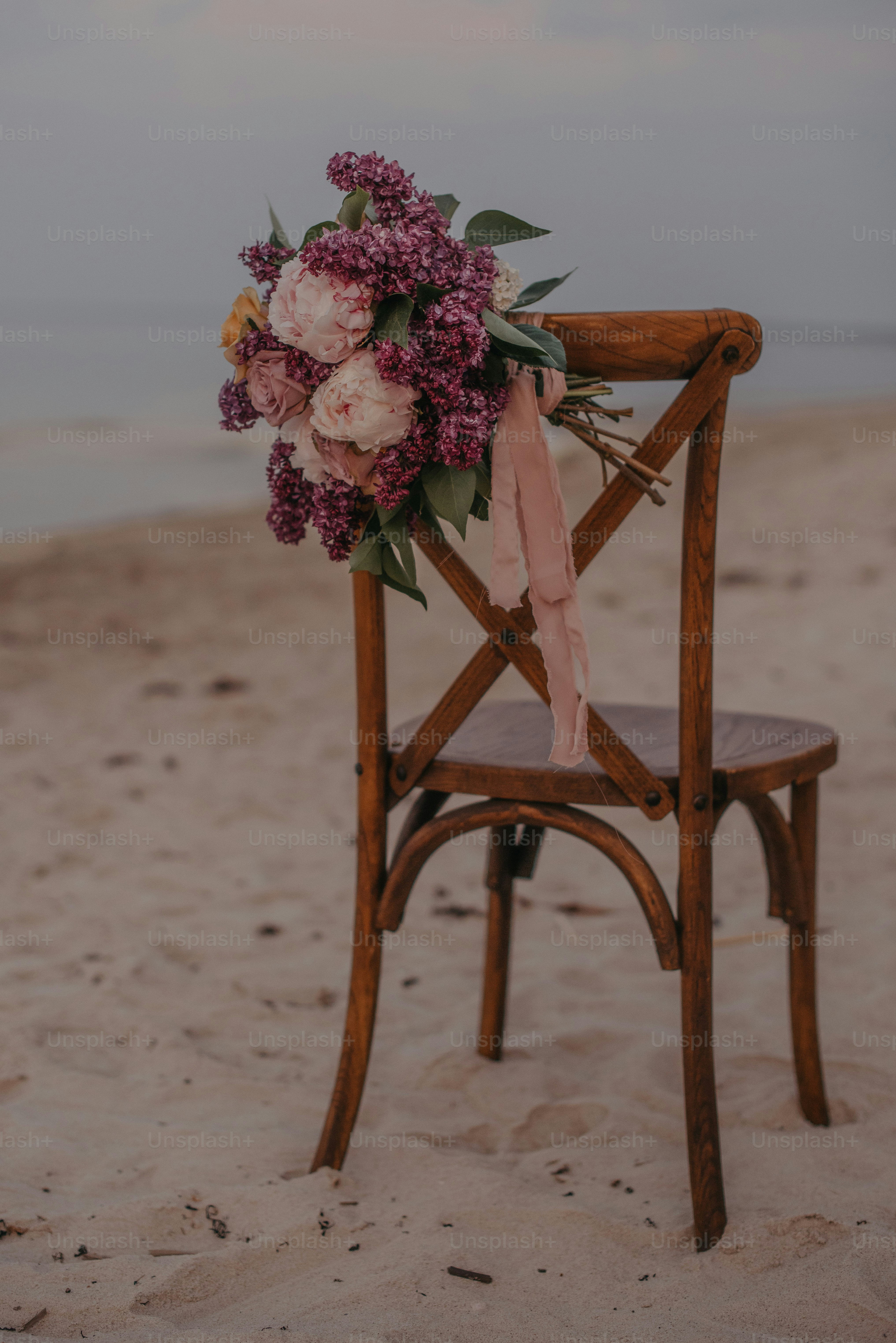 a wooden chair with a bouquet of flowers on it
