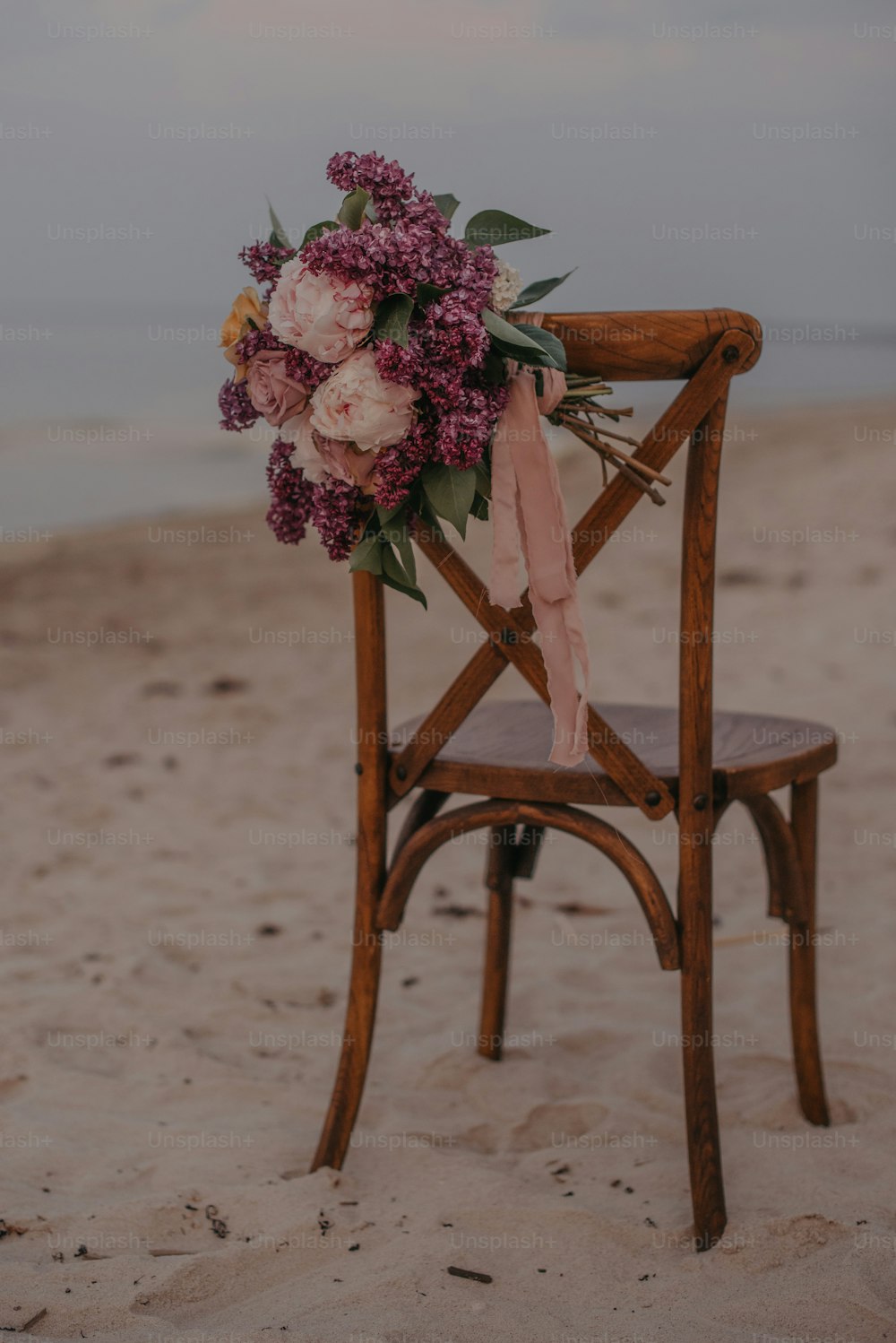 a wooden chair with a bouquet of flowers on it