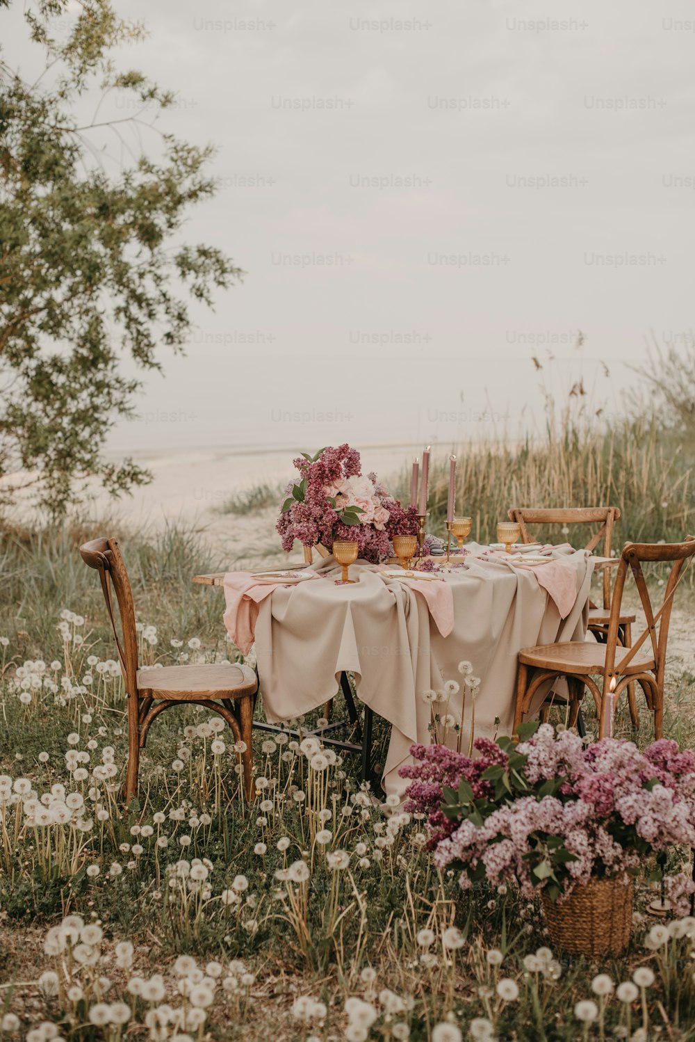 a table is set with a pink tablecloth and flowers