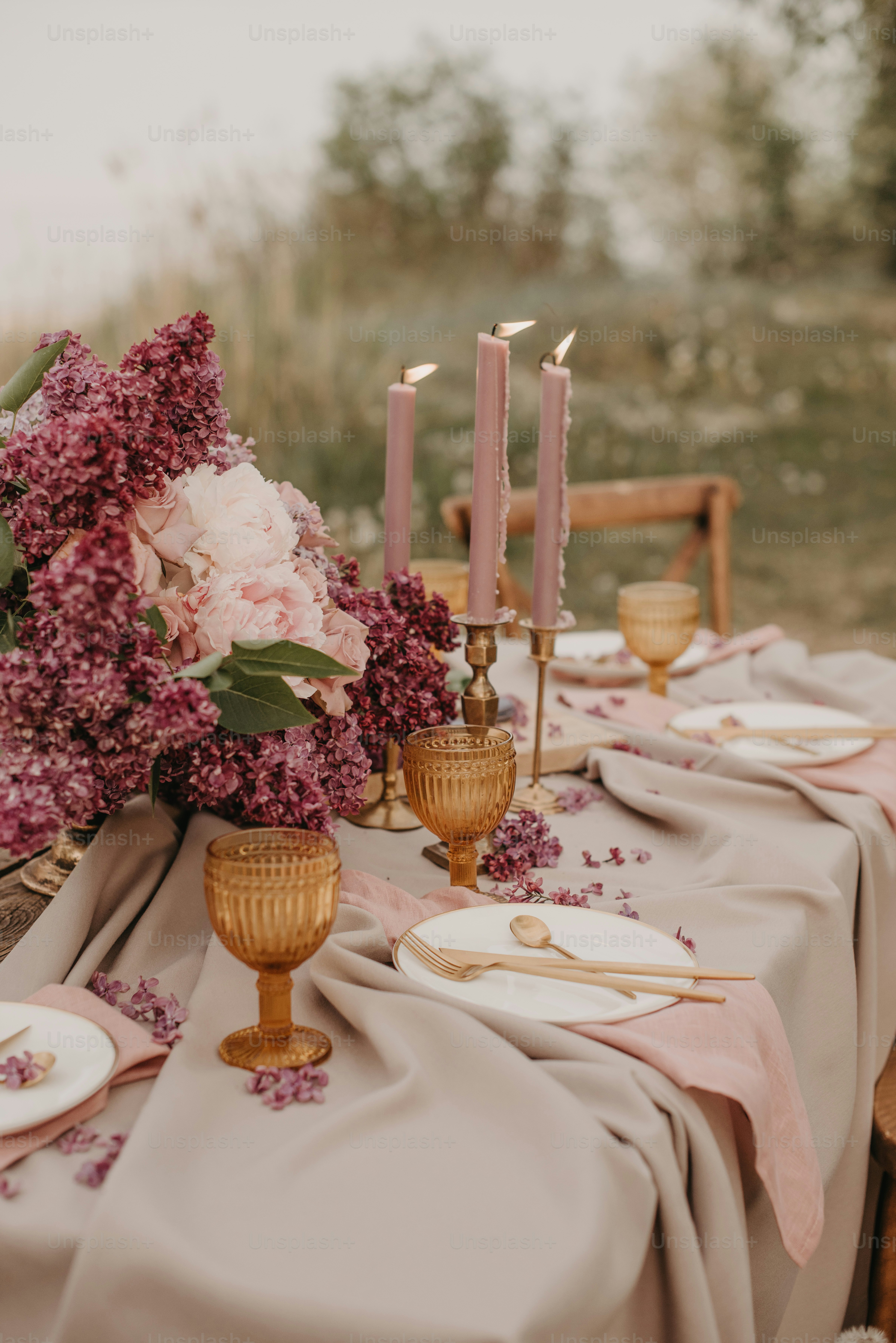 a table topped with a vase filled with purple flowers