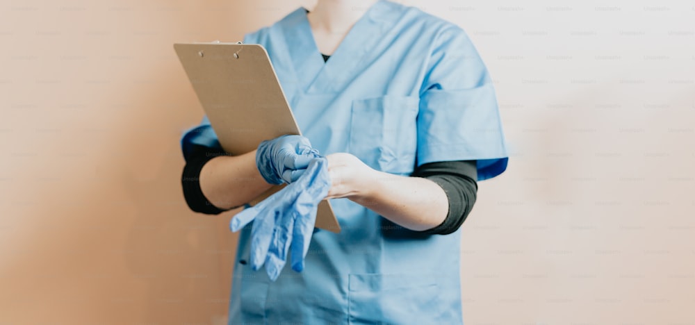 a person in scrubs is holding a clipboard