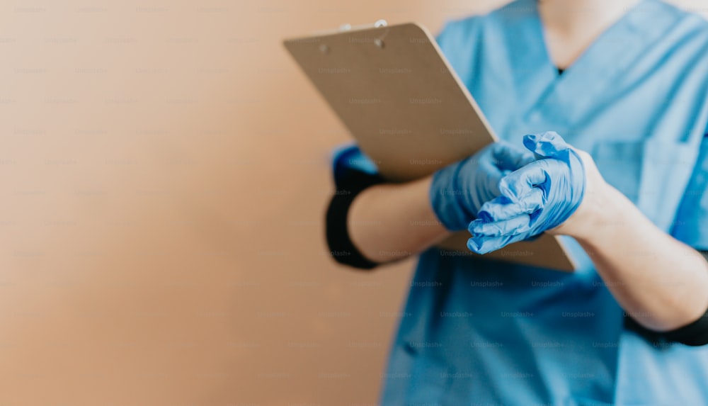 a woman in scrubs holding a tablet computer