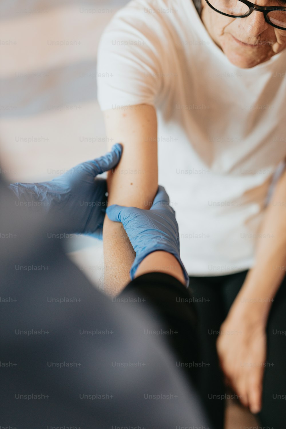 uma pessoa fazendo uma tatuagem no braço de outra pessoa