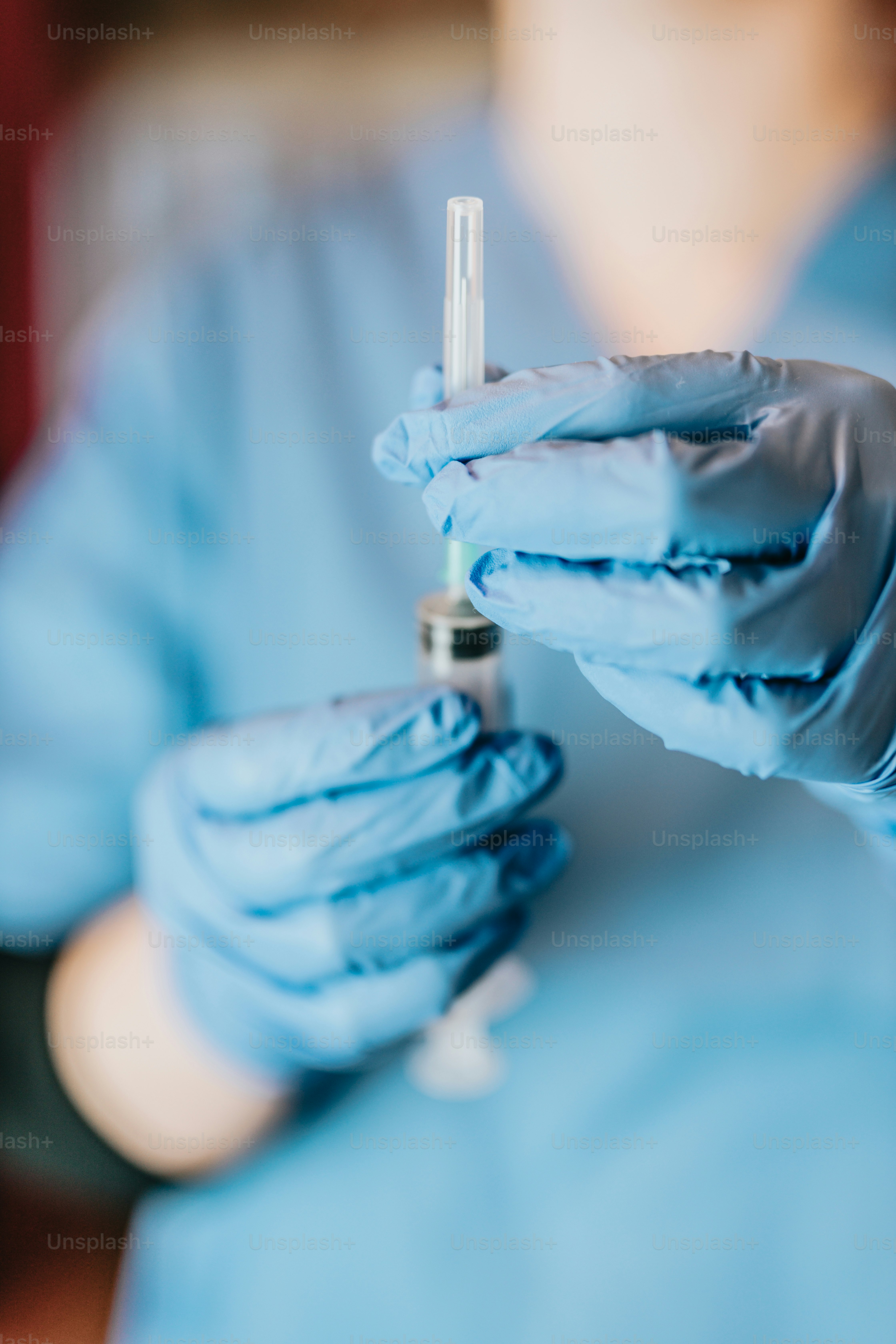 eine Person mit blauen Handschuhen, die eine kleine Pfeife hält