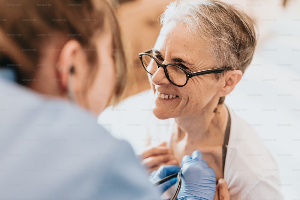 a woman with glasses and a stethoscope is smiling