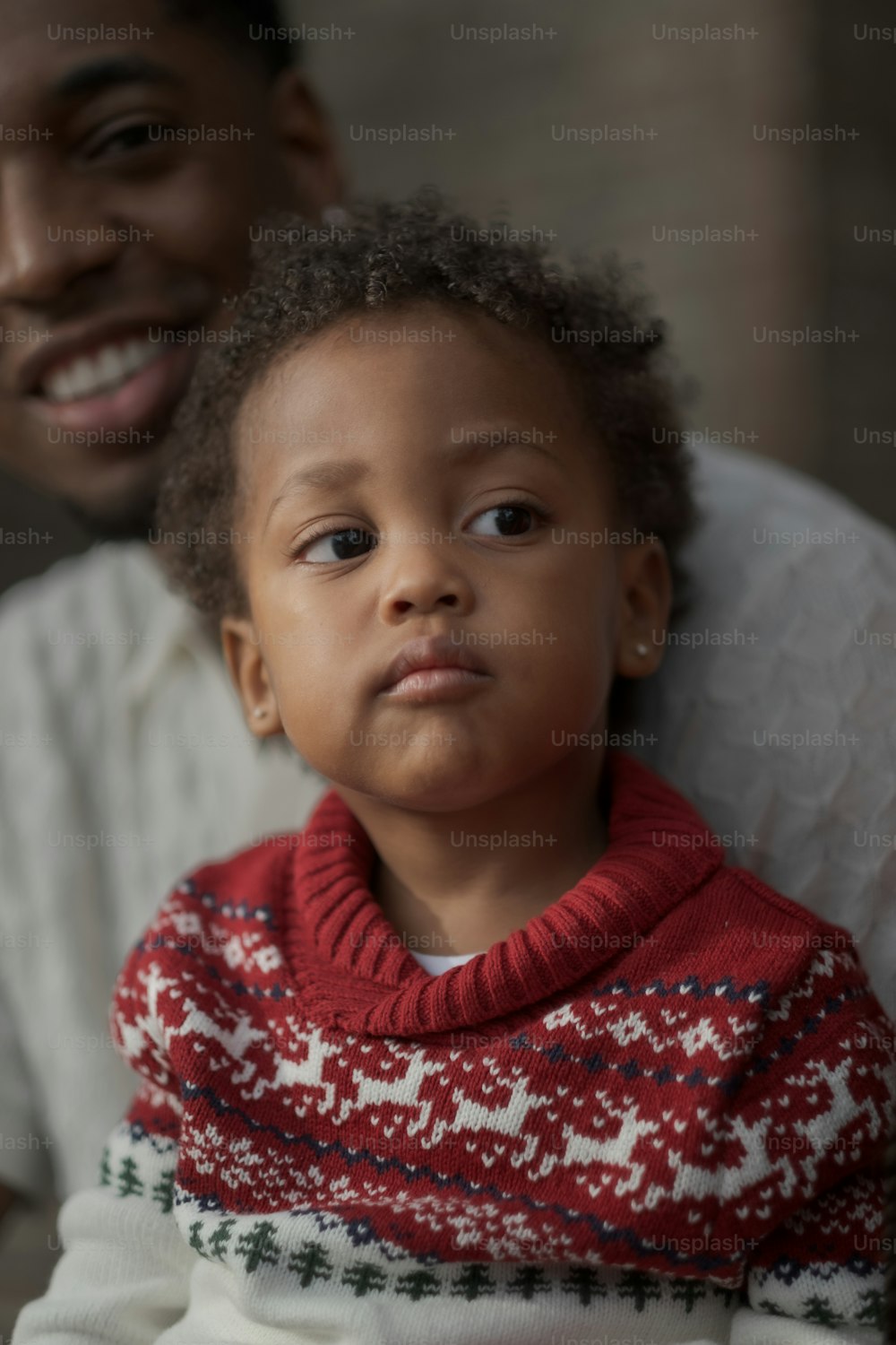 a man holding a small child wearing a sweater