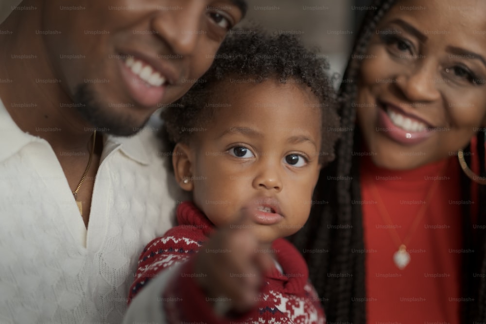 a man and woman with a child pointing at the camera