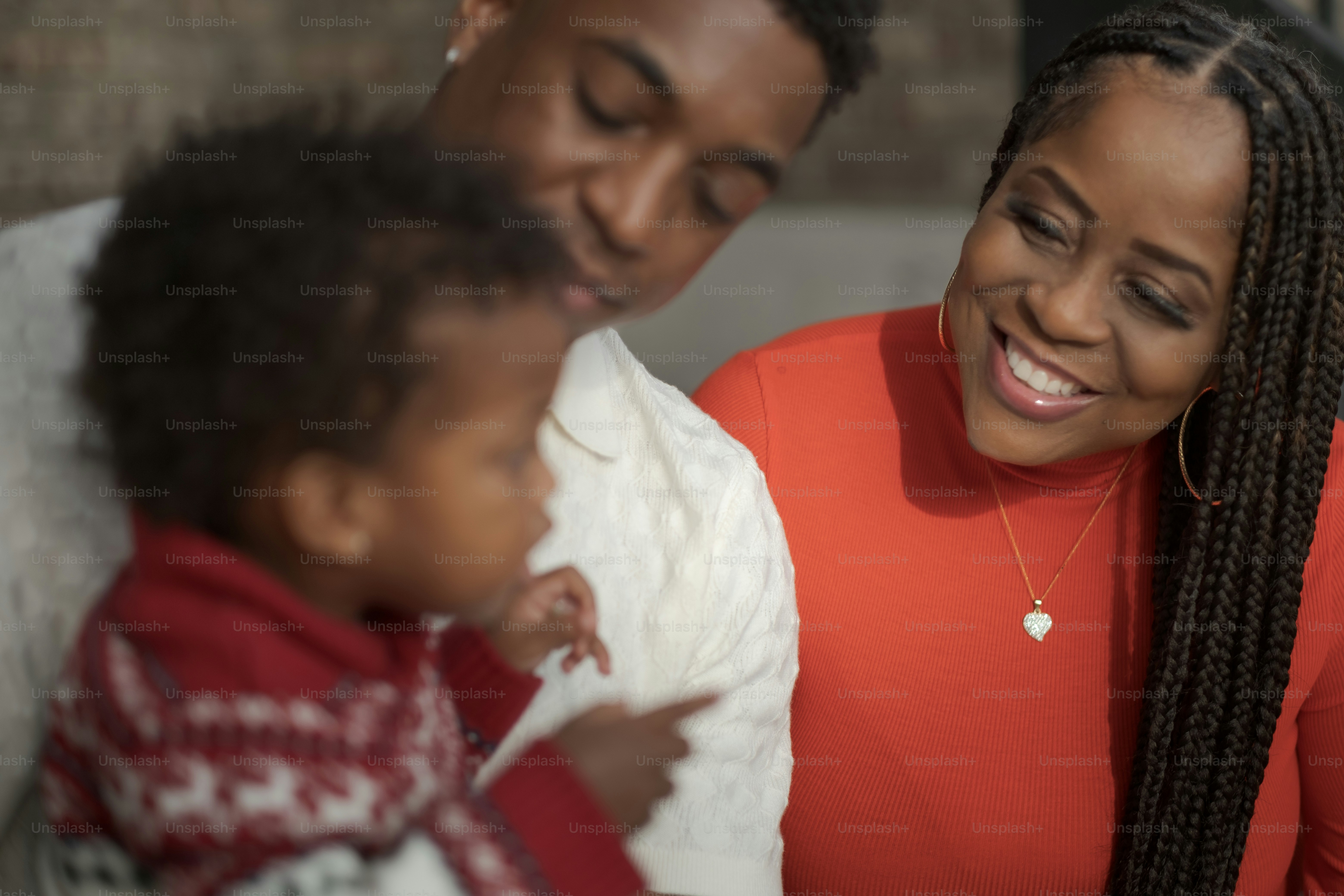 a man and a woman smile as they hold a baby