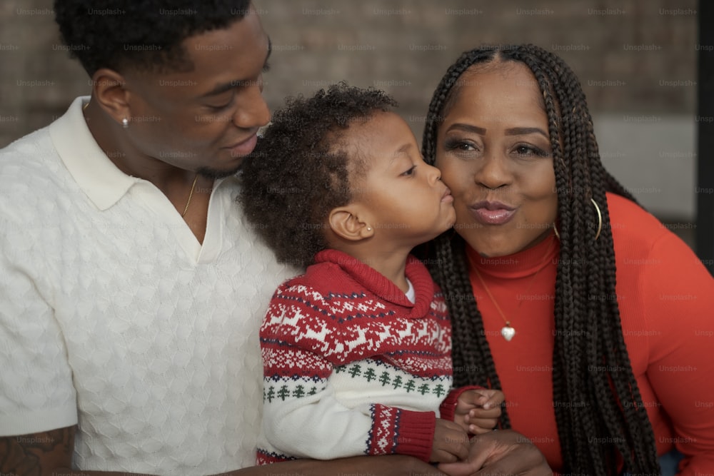 a woman and a man are kissing a little girl