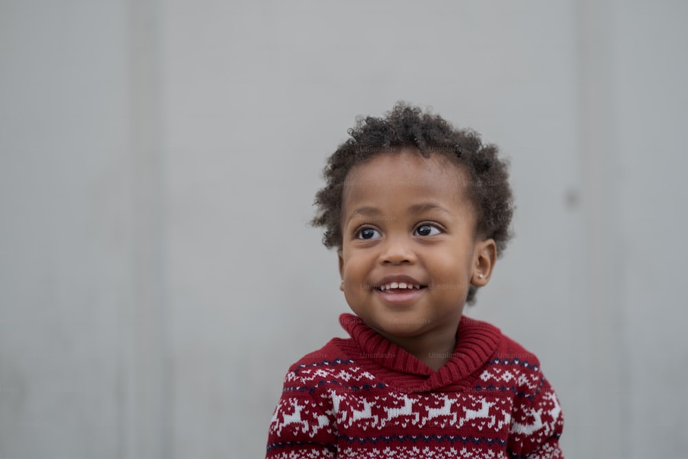 a young child wearing a red and white sweater