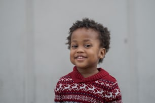 빨간색과 흰색 스웨터를 입은 어린 아이