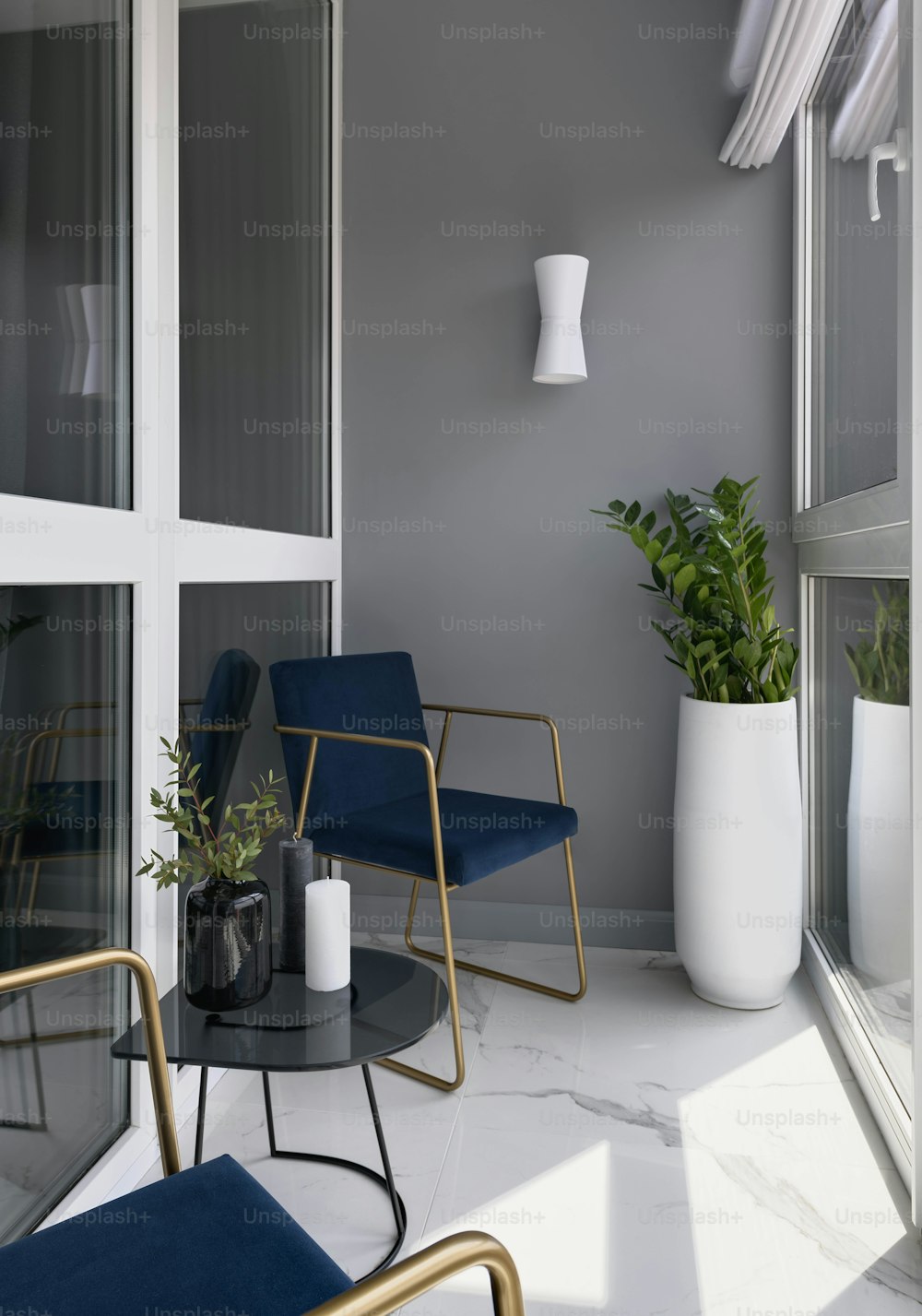 a room with two chairs, a table and a plant