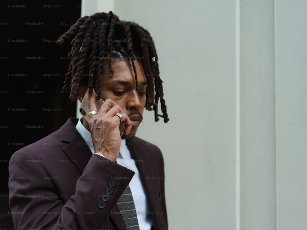 a man with dreadlocks talking on a cell phone