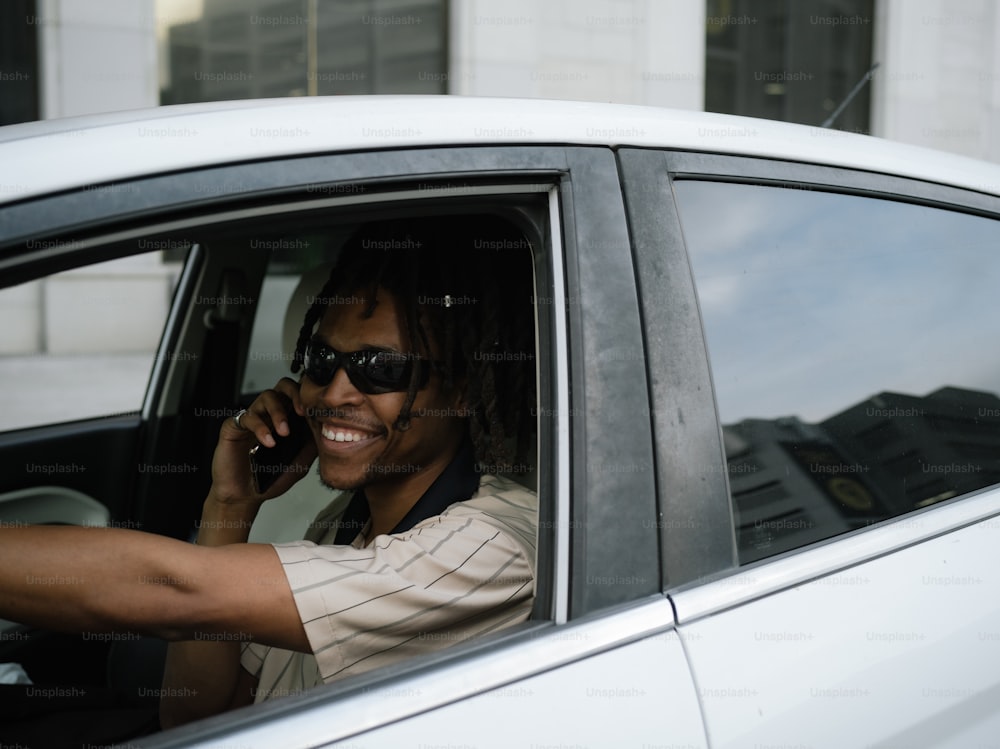 a woman sitting in a car talking on a cell phone