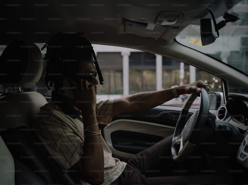 a man driving a car while talking on a cell phone
