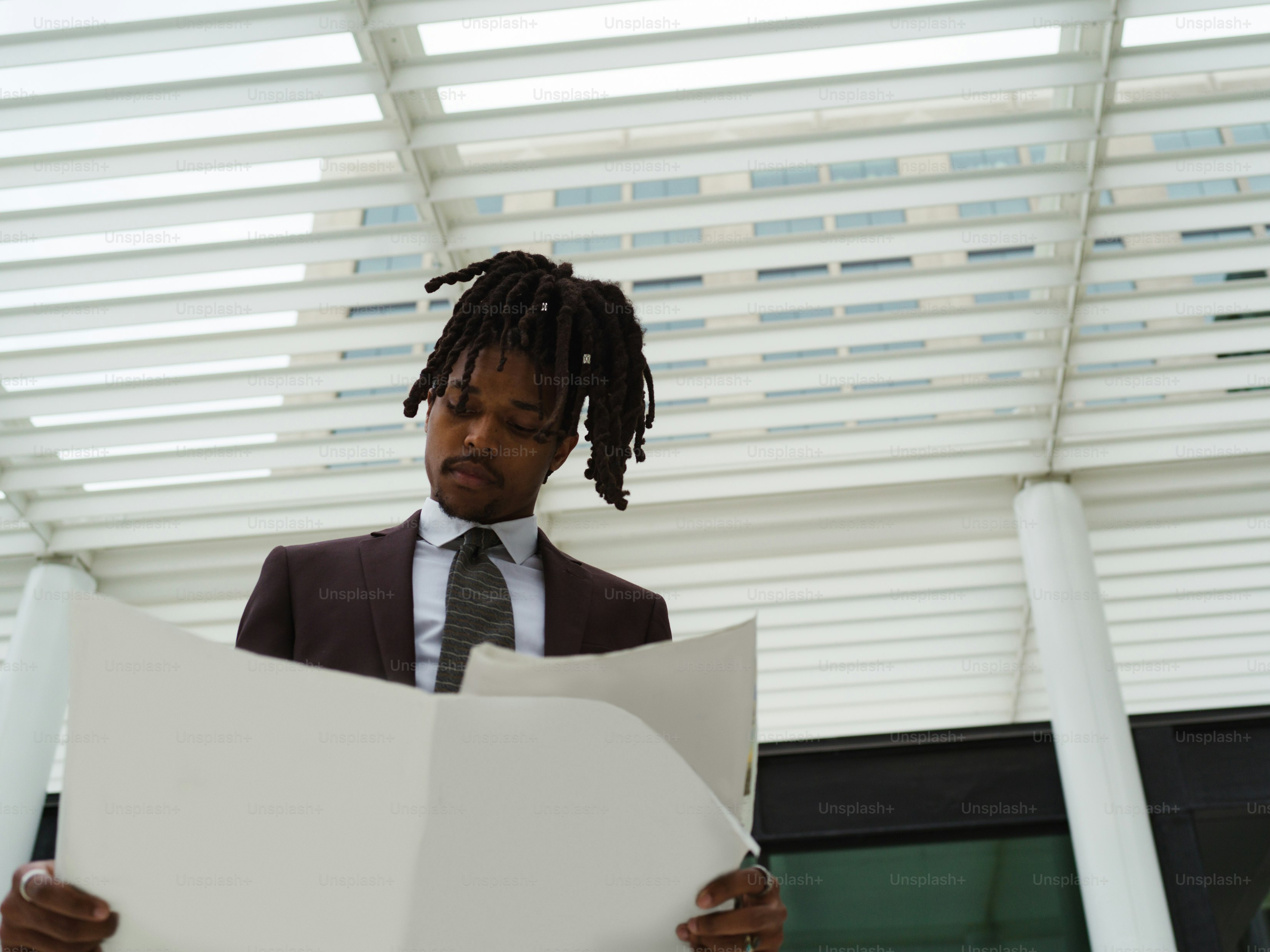 a man in a suit and tie reading a piece of paper