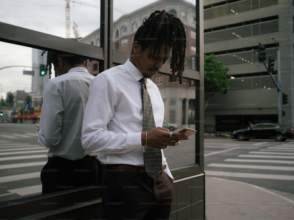 a man in a white shirt and tie looking at his cell phone