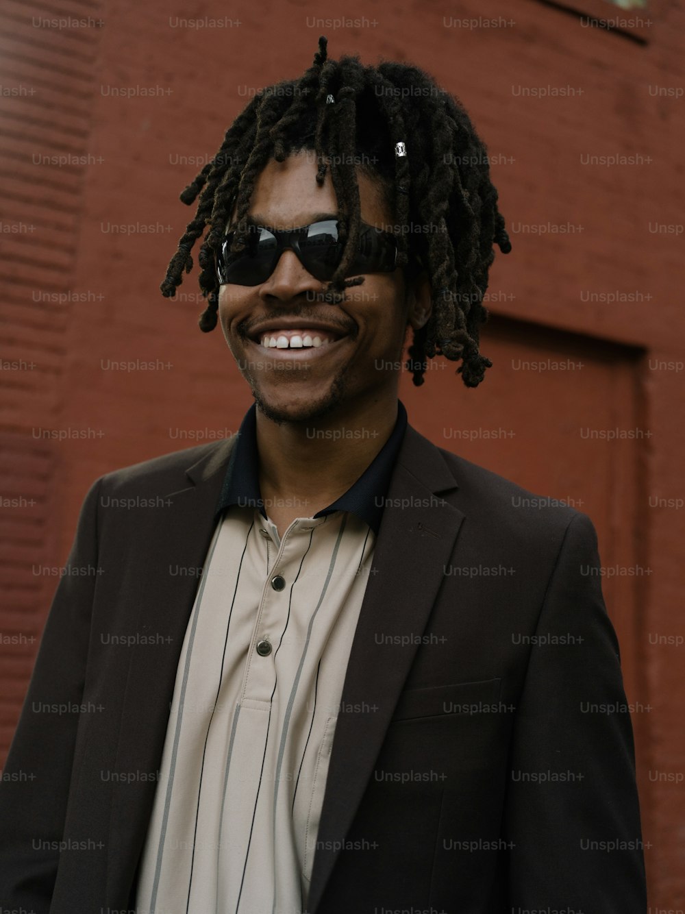a man with dreadlocks wearing a suit and sunglasses