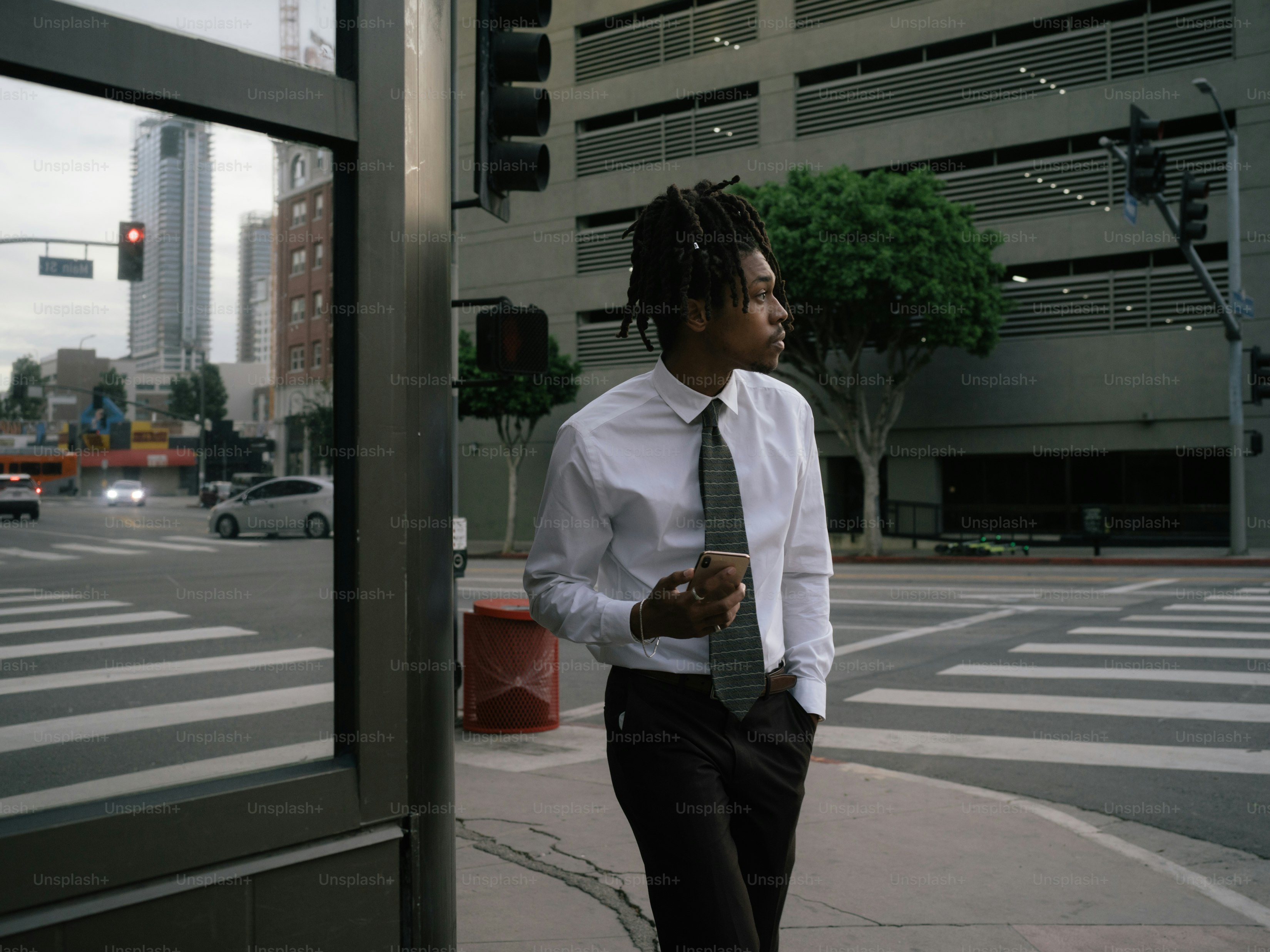 a man in a white shirt and tie walking down the street