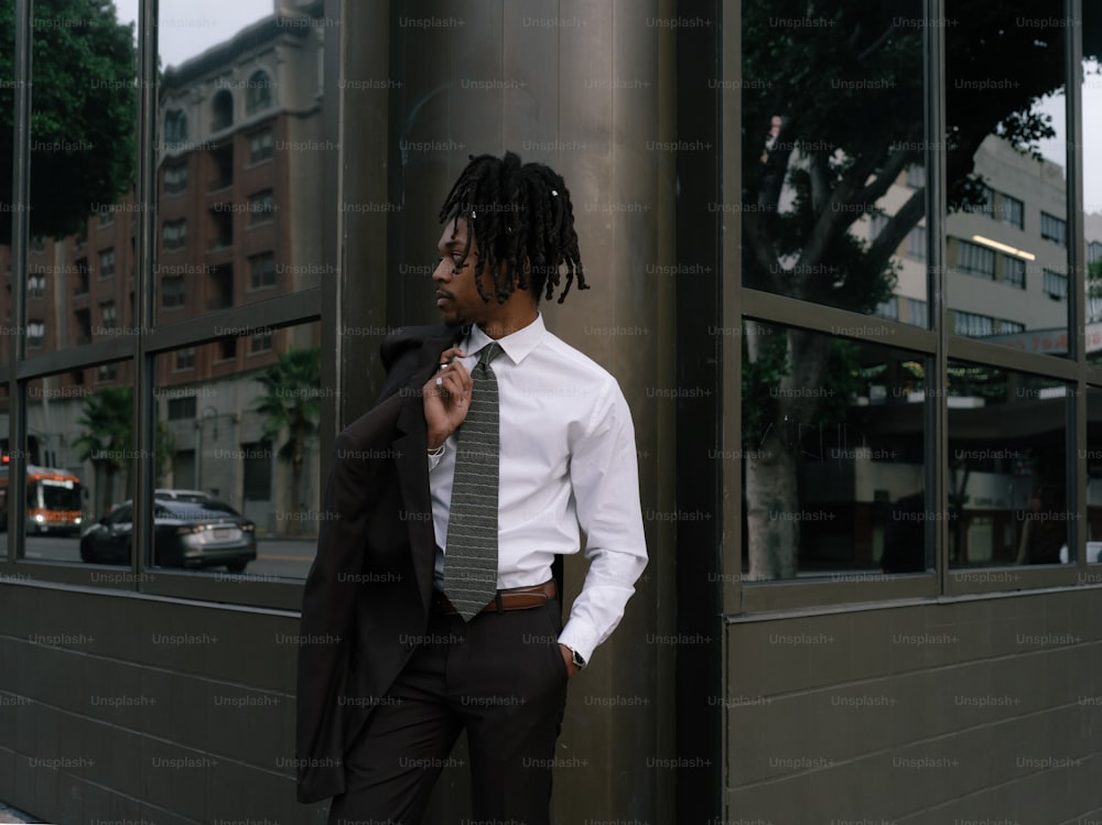 um homem de terno e gravata em pé na frente de um prédio