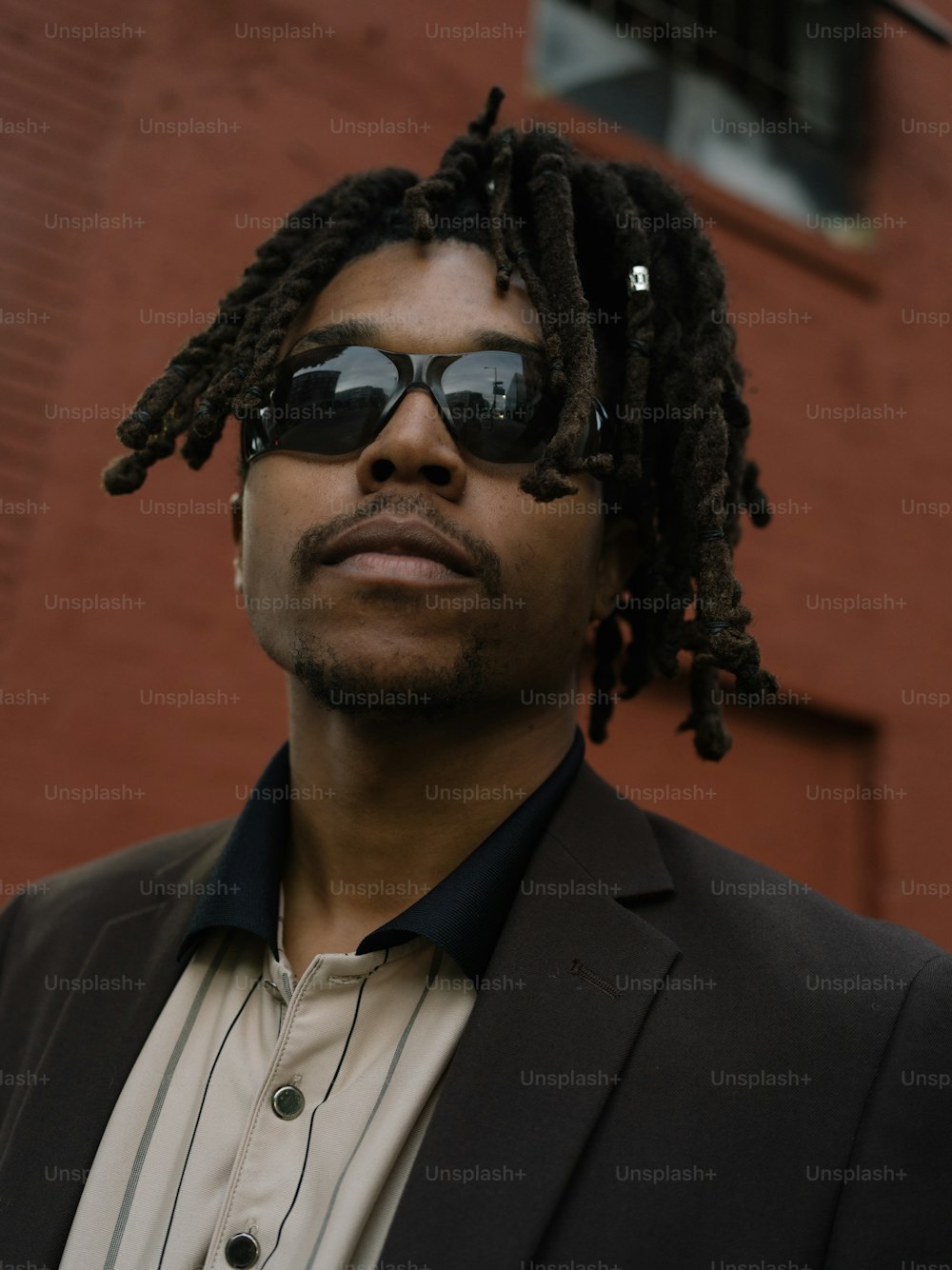 a man with dreadlocks standing in front of a building