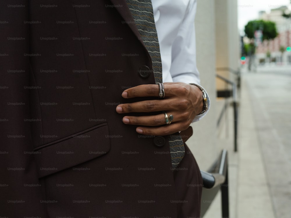 a man in a suit and tie with his hand on his lapel