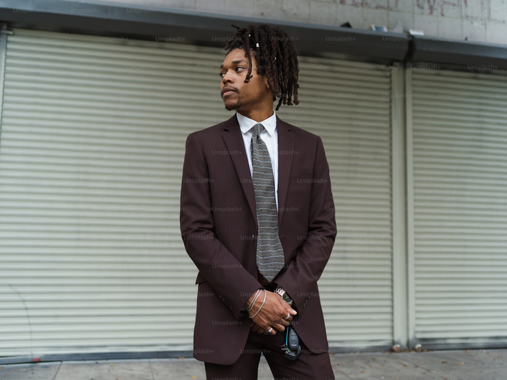 a man in a suit and tie standing in front of a building