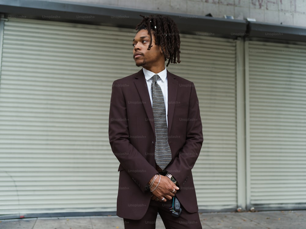 um homem de terno e gravata em pé na frente de um prédio
