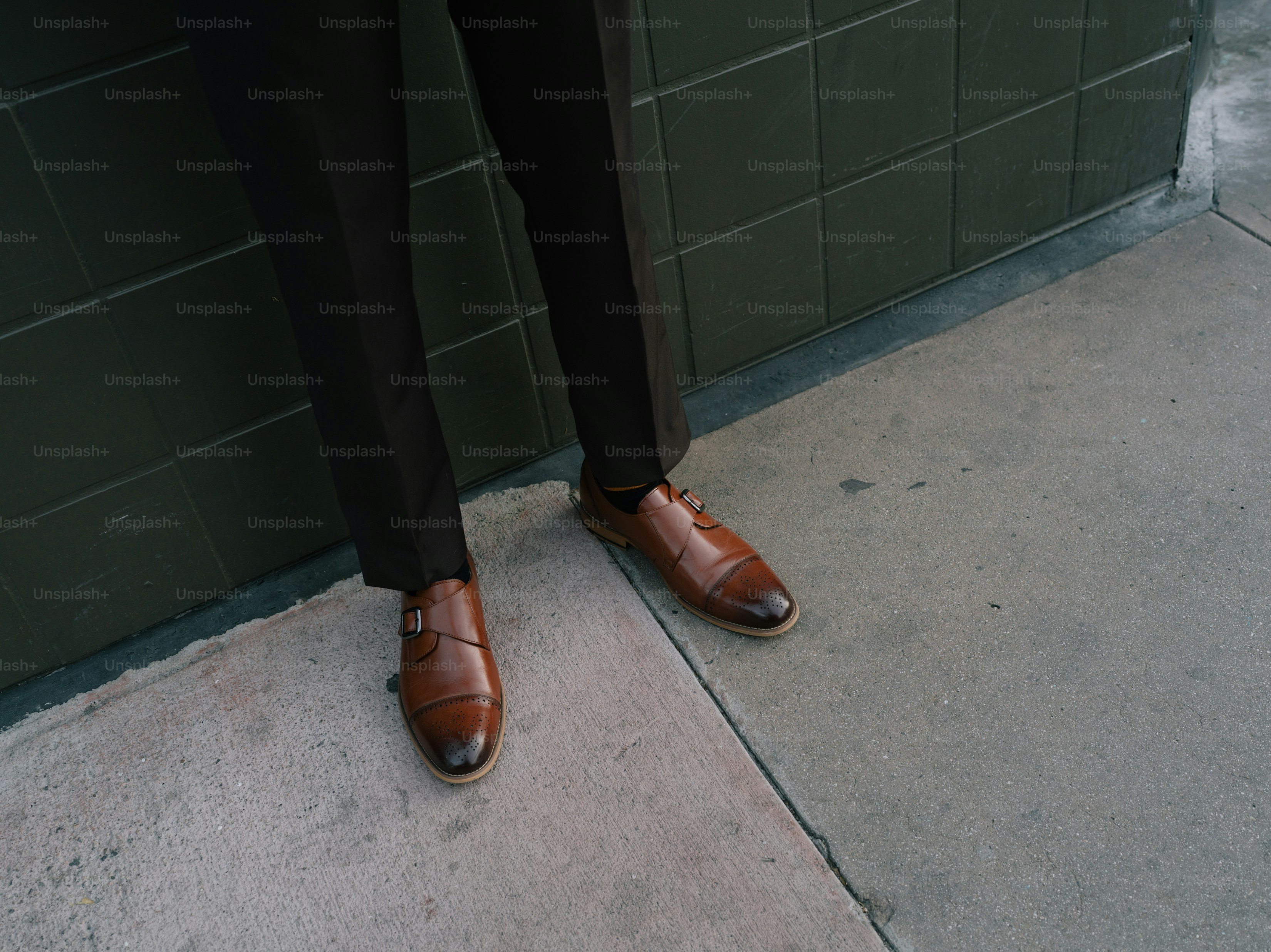 a man in a suit and tie standing next to a wall