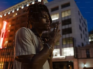 a man with dreadlocks standing in front of a building