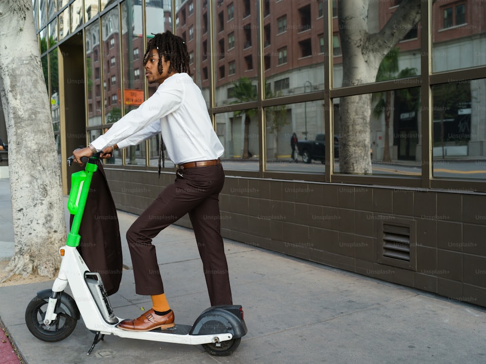 a man riding a scooter on a city street