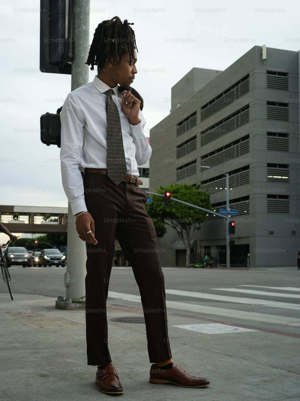 a man in a suit and tie standing on a street corner